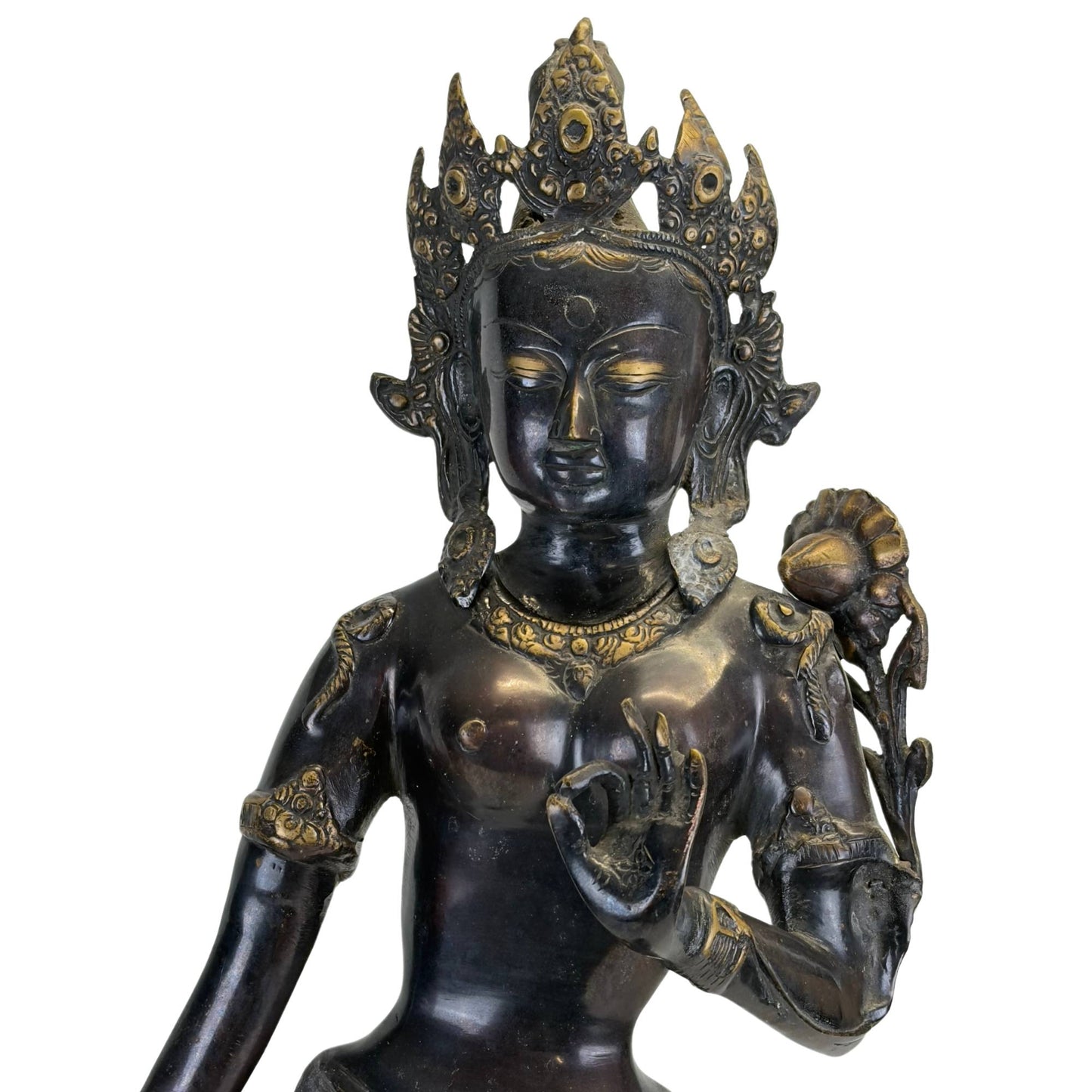 Left front of an antique Newar Green Tara with richly engraved robes and lotus stem.
