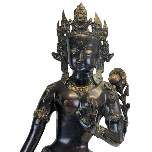 Left front of an antique Newar Green Tara with richly engraved robes and lotus stem.
