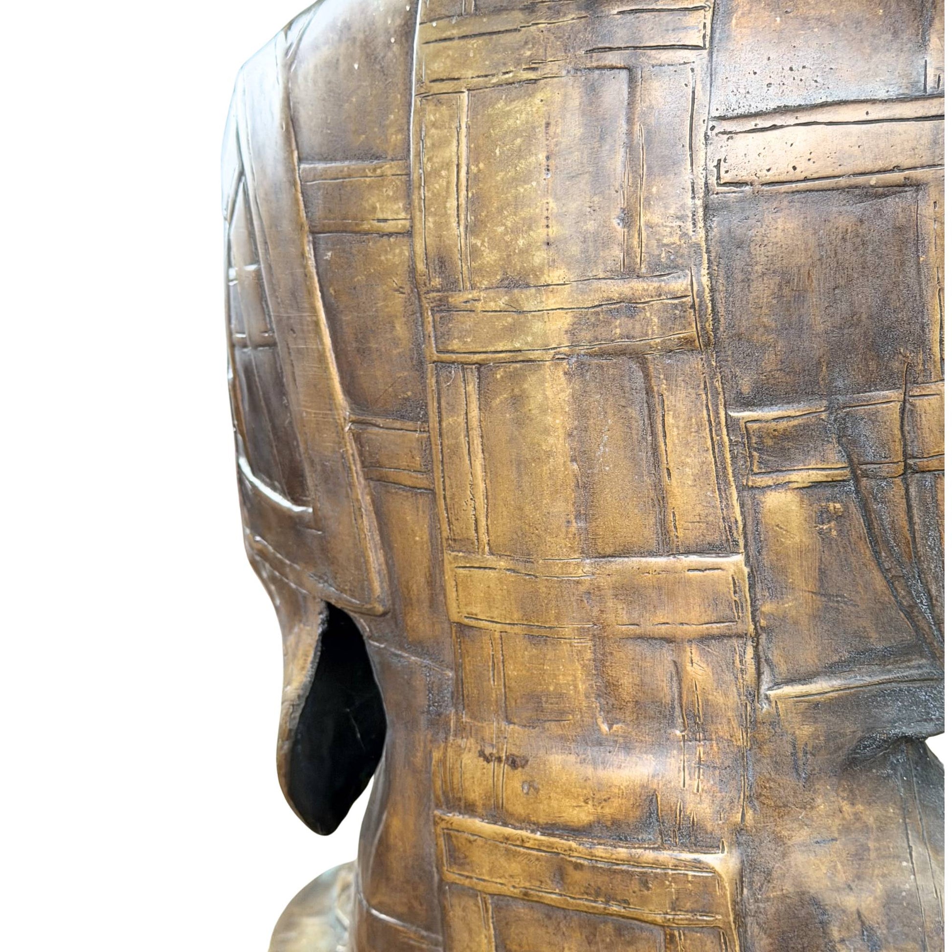 Large antique bronze temple statue of Buddha with fire-gilded remnants, serene appearance and museum collection presentation, antique pattern of rice fields from Tibet