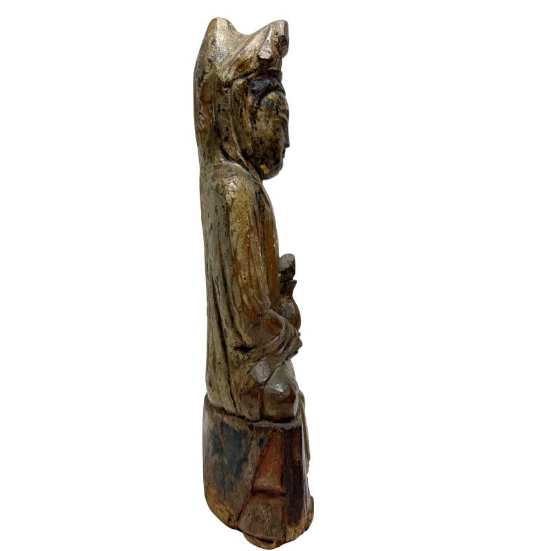 Hand-carved wooden Guanyin statue with a weathered patina and a serene appearance.