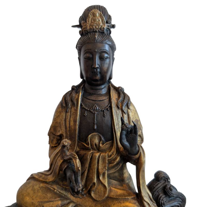Seated Guanyin on a lion as a bronze statue