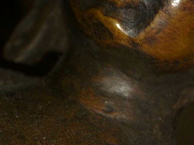 Microscope detail of hand finishing on bronze Buddha with meditation mudra