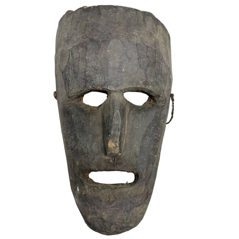 Hand-carved wooden mask from Nepal with an elongated face in dark wood
