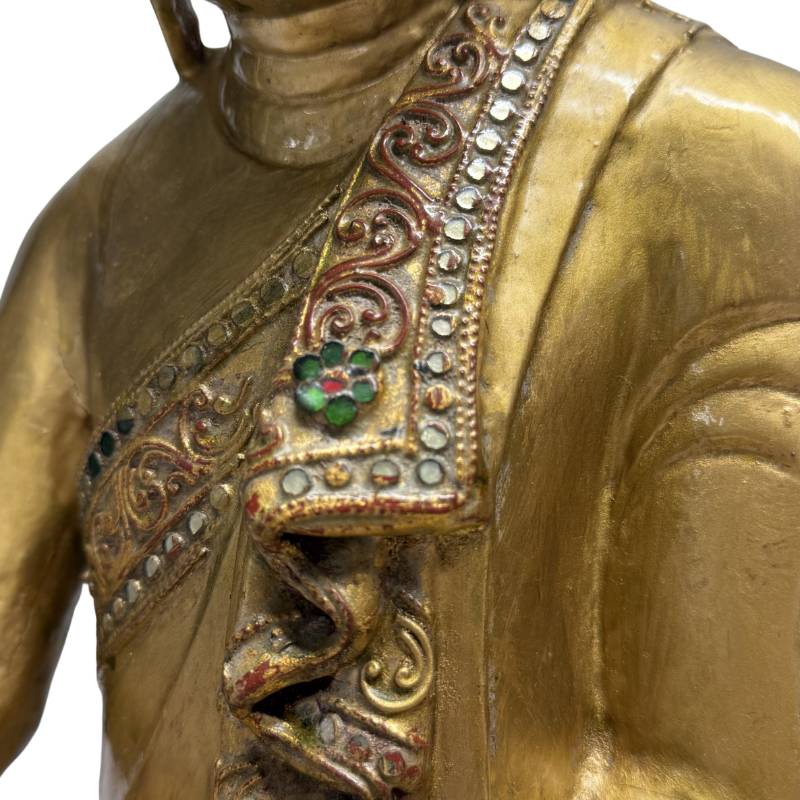 Wooden Buddha statue with a calm and gentle facial expression
