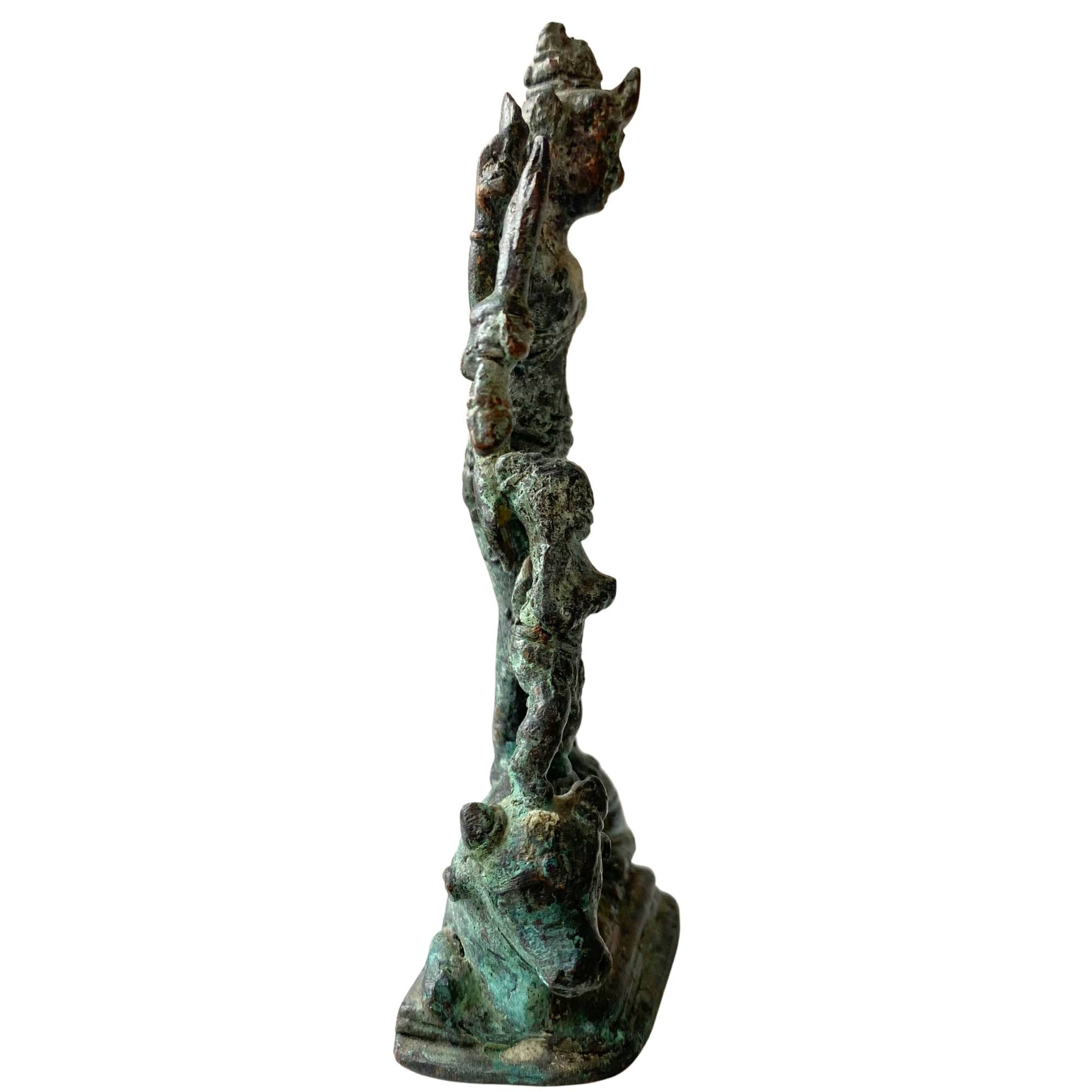 Side view of the bronze Durga focusing on the natural mineral deposits.