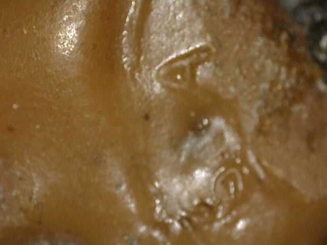 Detail of an old lacquer or wax stamp in the hair structure of a Chinese Buddha statue