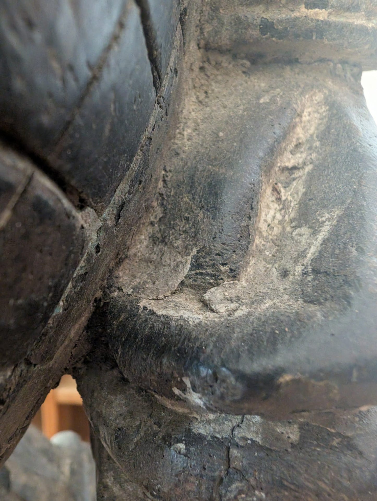 Detail of authentic carving in a wooden Lakshmi statue from Nepal with aged texture and wear
