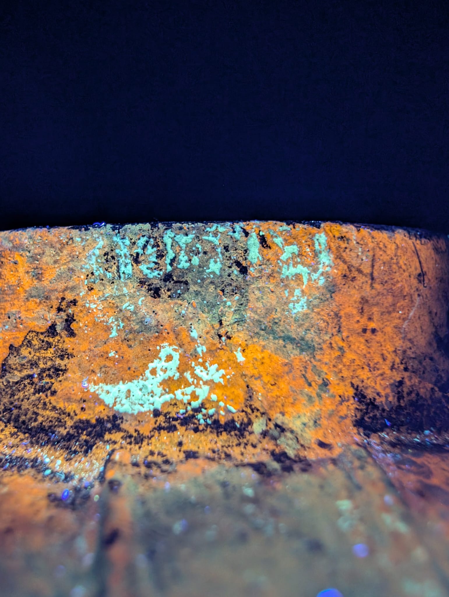Macro photograph of the black magnetite layer characteristic of old cast iron.