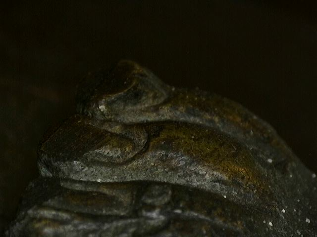 Microscope detail of deep patina buildup on antique Thai bronze artwork