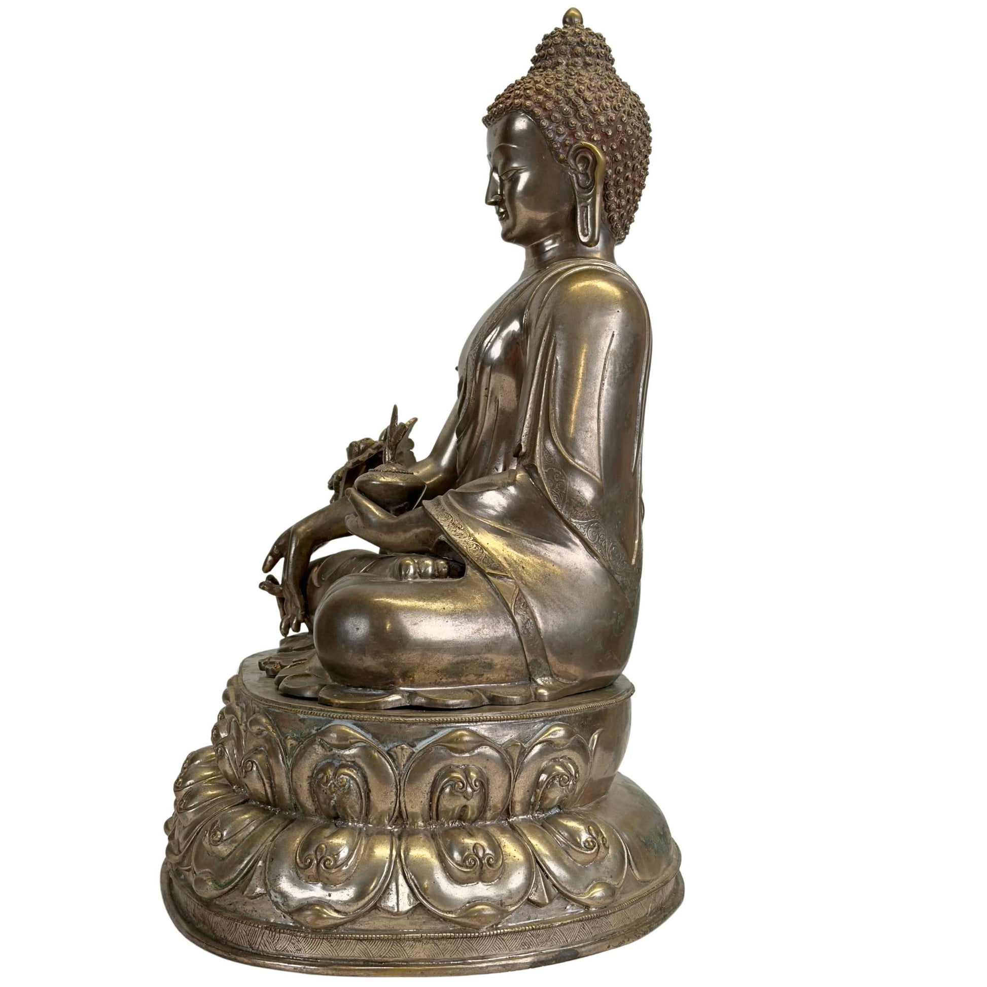 Right side of an antique Newar Bhaisajyaguru in silver-plated bronze with medicine pot, engraved monk's robe, two-part lotus throne, and natural patina consistent with great age.