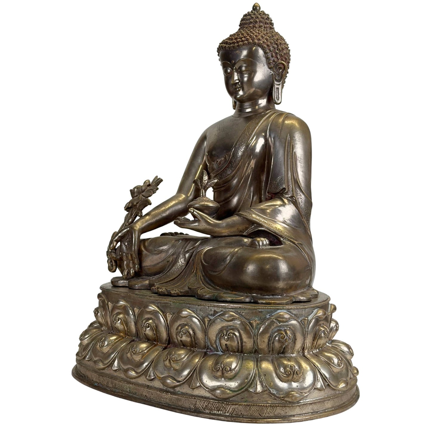Oblique front view of an antique Newar Bhaisajyaguru in silver-plated bronze with medicine pot, large myrobalan plant, finely engraved robes, two-part lotus throne, and natural patina.