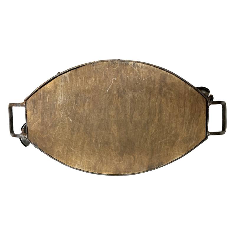 Bottom of a small bronze dish from a French table setting
