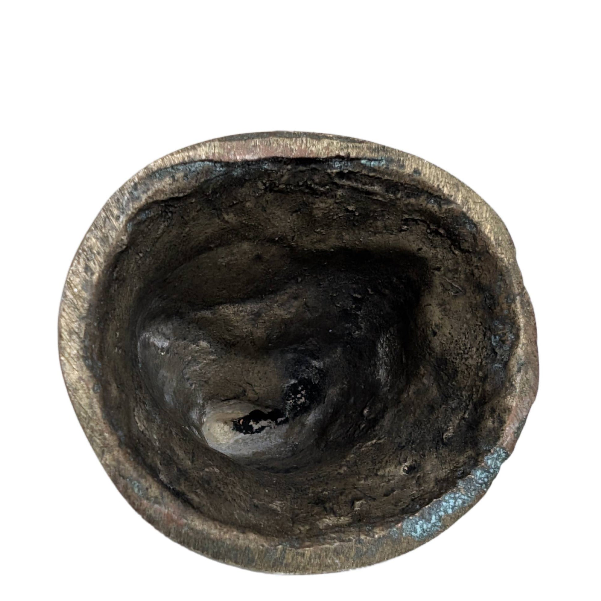 The hollow underside of the hand-cast brass Buddha figurine.