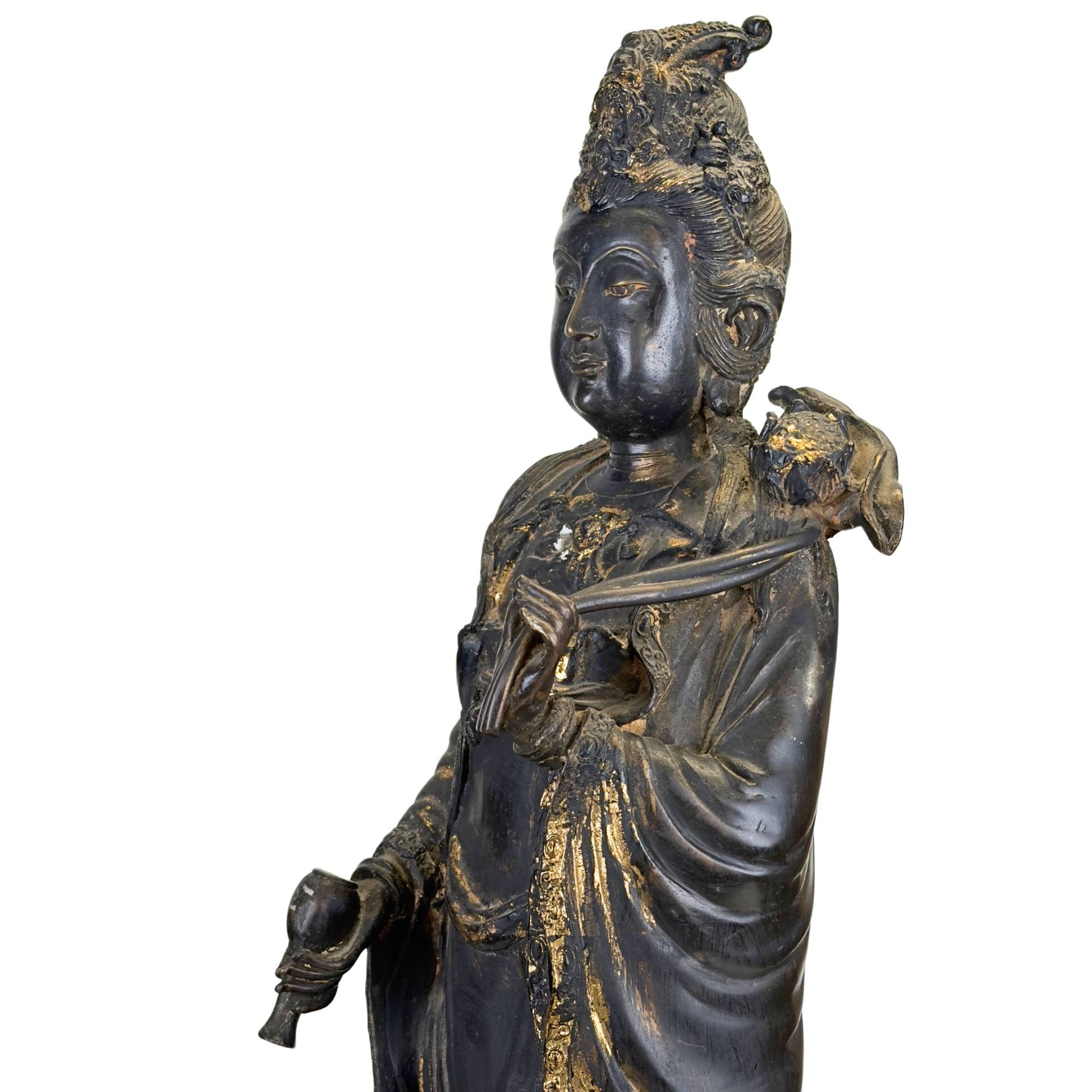 East Asian bodhisattva sculpture in bronze with dark patina and temple-like appearance