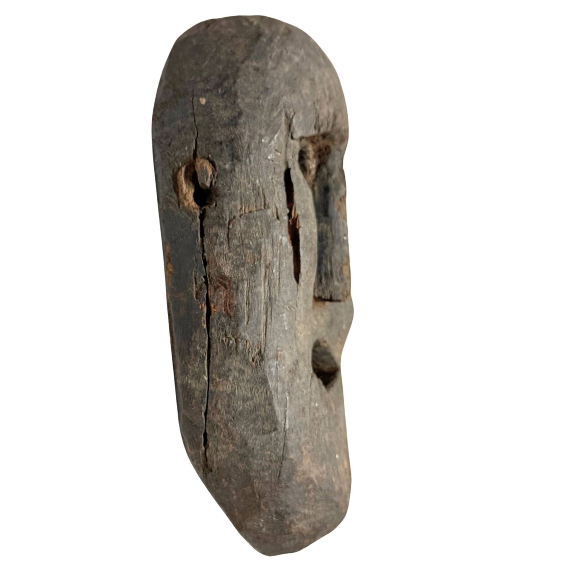 Old tribal wooden shaman mask, authentic handmade mask with weathered skin and powerful expression