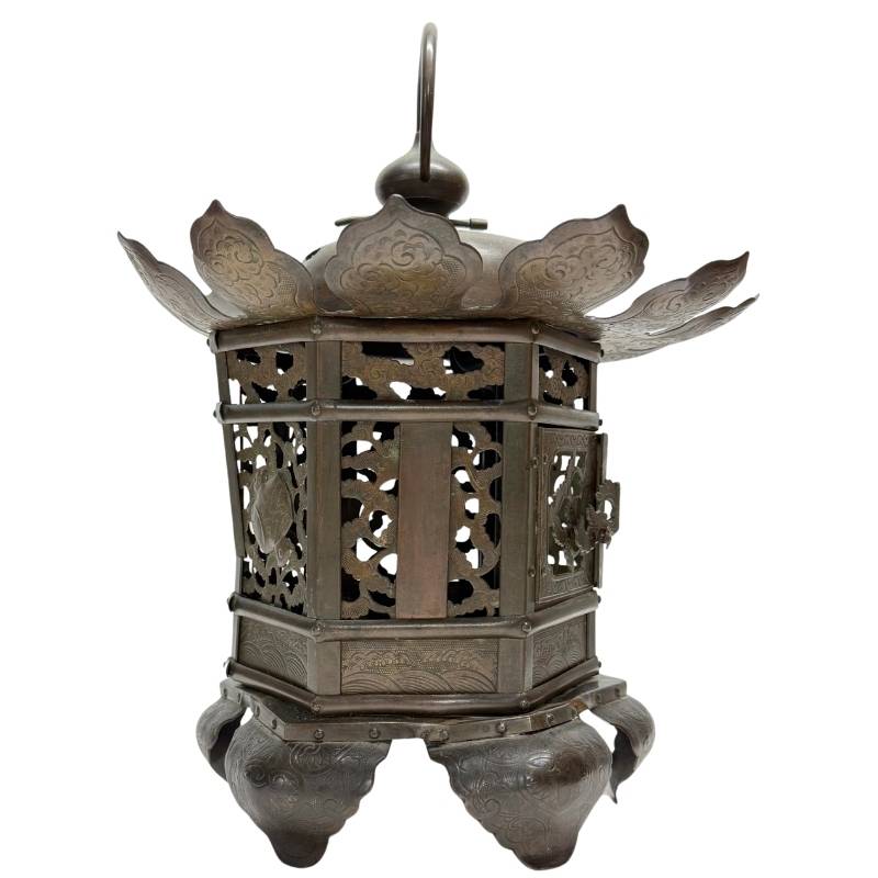 Old temple lantern of openwork bronze, richly decorated with floral panels and a ritual appearance.