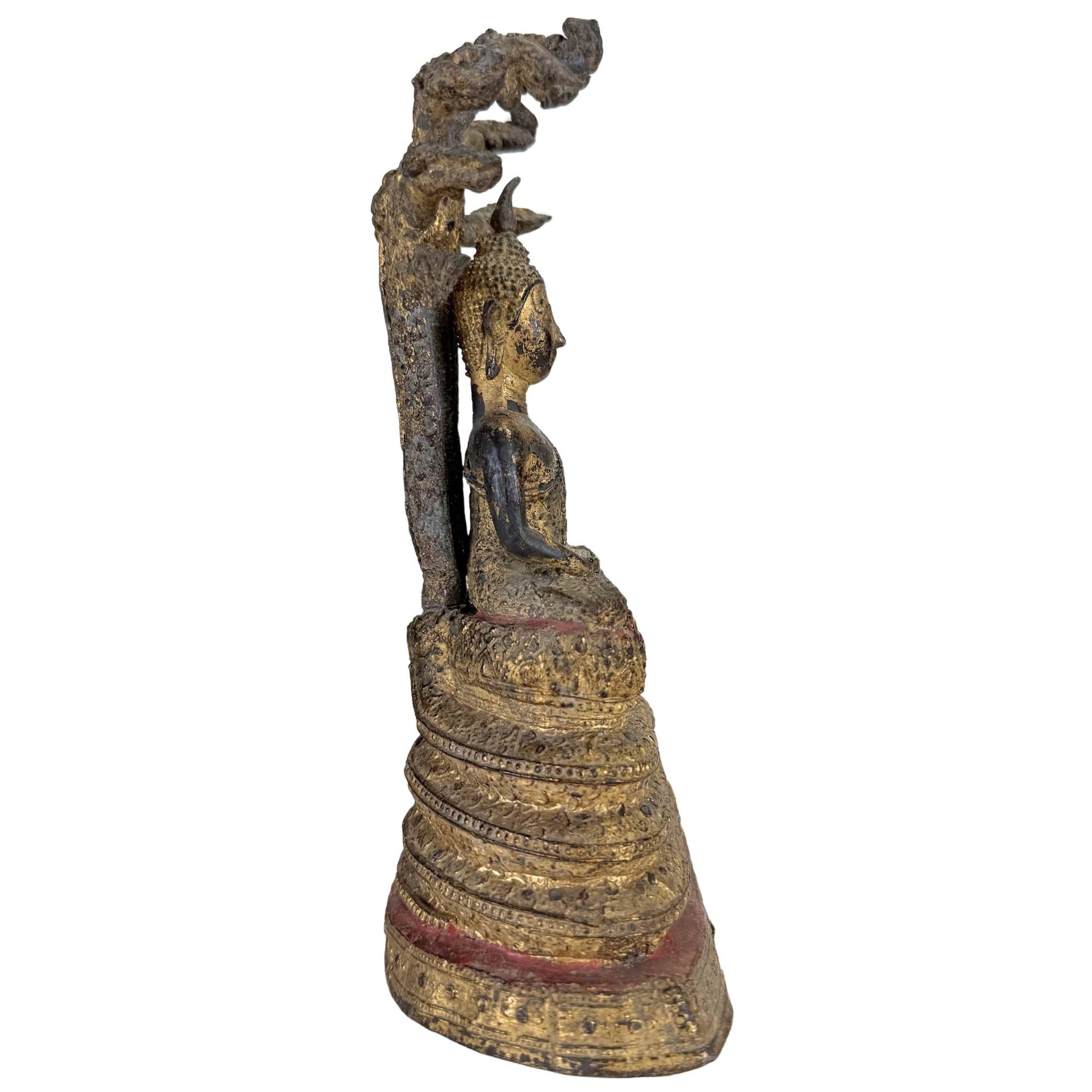 Old Thai Buddha under protective Muchalinda Naga with weathered gilding