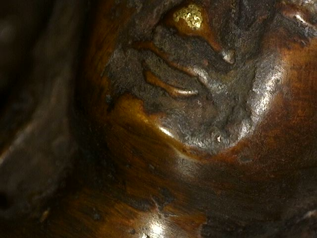 Microscope photograph of patina layers on a Himalayan bronze Buddha with Dhyana Mudra