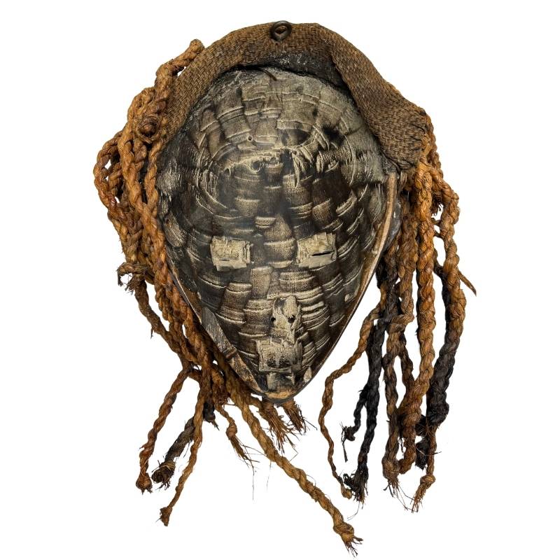 Ritual African mask with round cheek markings, elongated face, and hand-carved openwork headdress