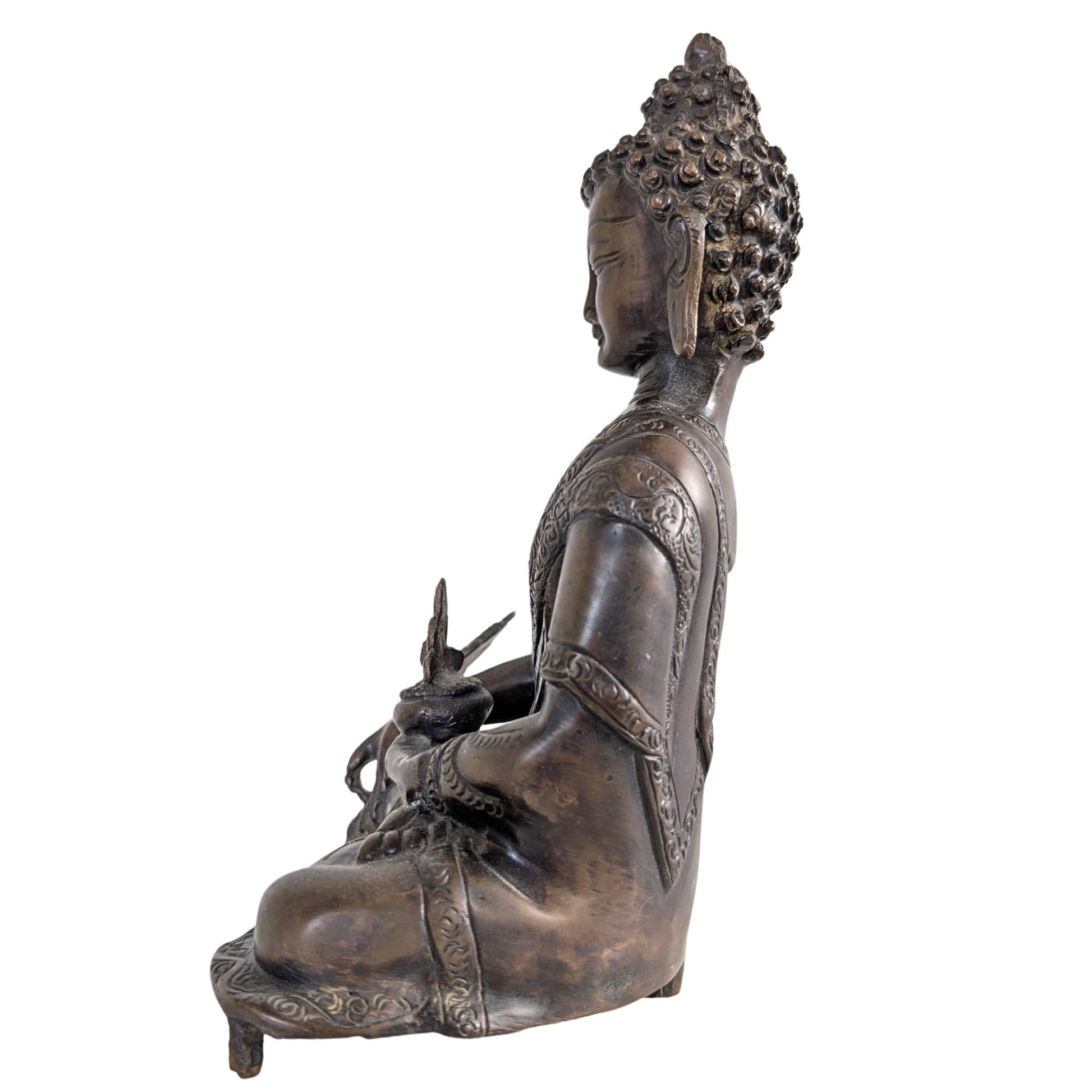 Close-up of the serene face and the traditional bun on the bronze statue.