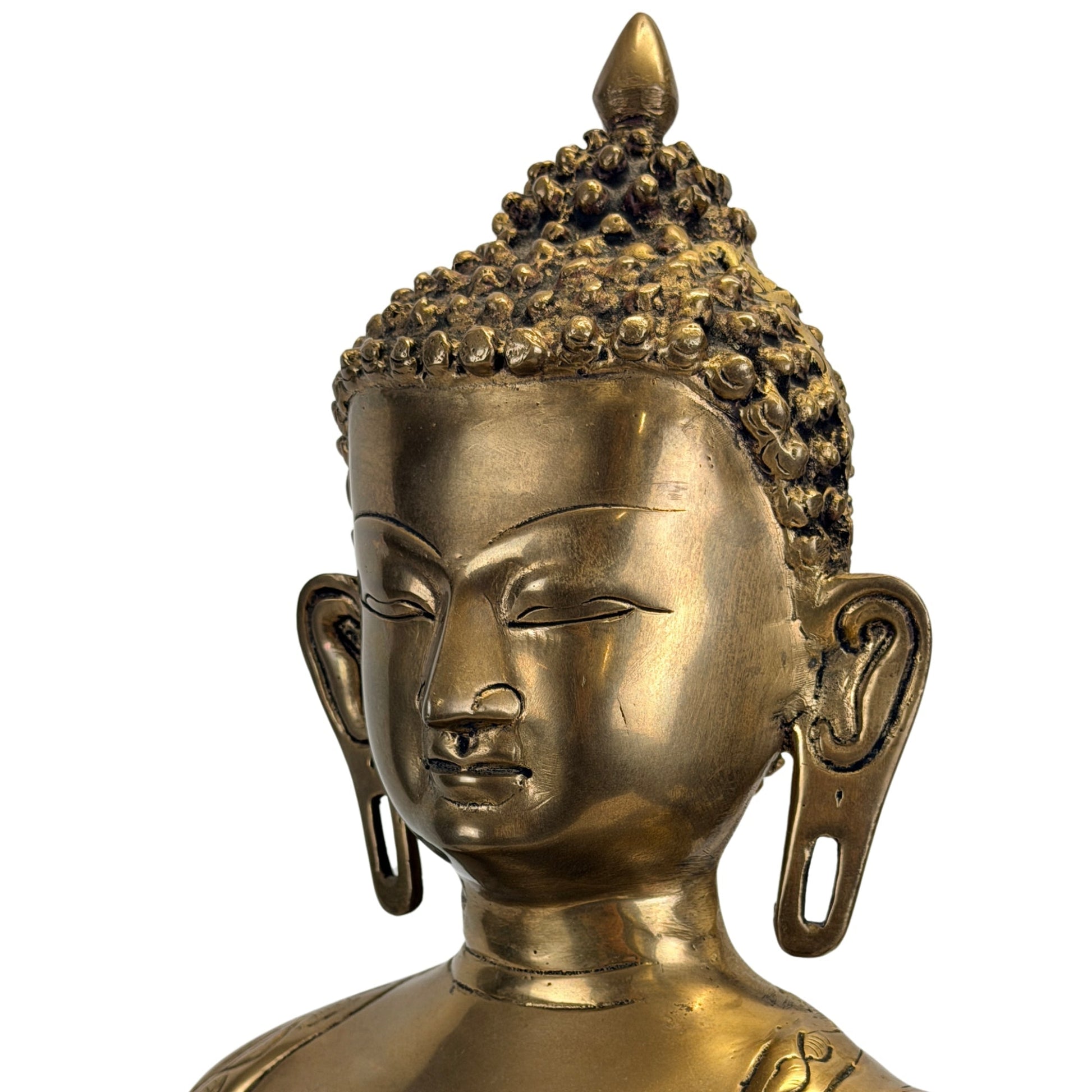 Detail van het gezicht en de langgerekte oorlellen van Shakyamuni Boeddha
