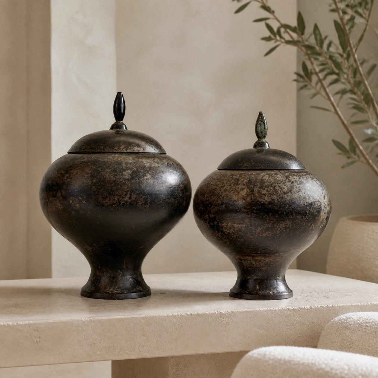 Pair of Indian bronze covered vessels with dark patina in a Wabi-Sabi interior