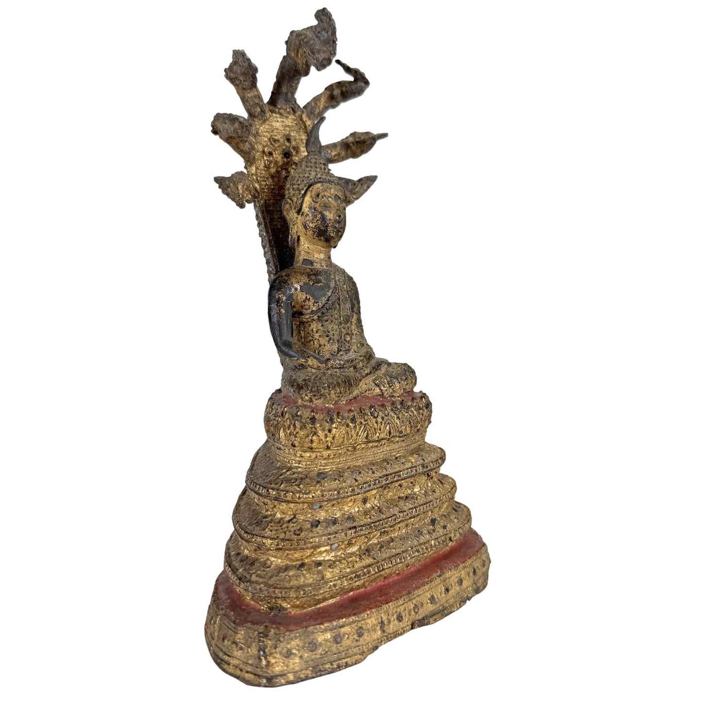 Side view of antique Thai Naga Buddha with gilded finish and multi-headed snake