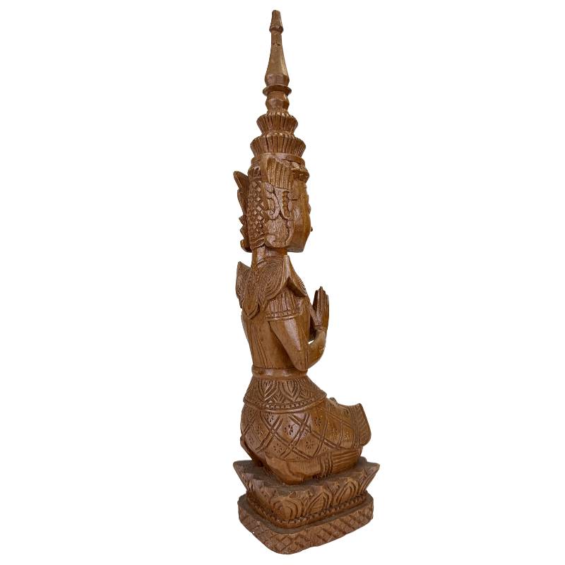 Thai wooden Thepanom figure kneeling in a posture of devotion