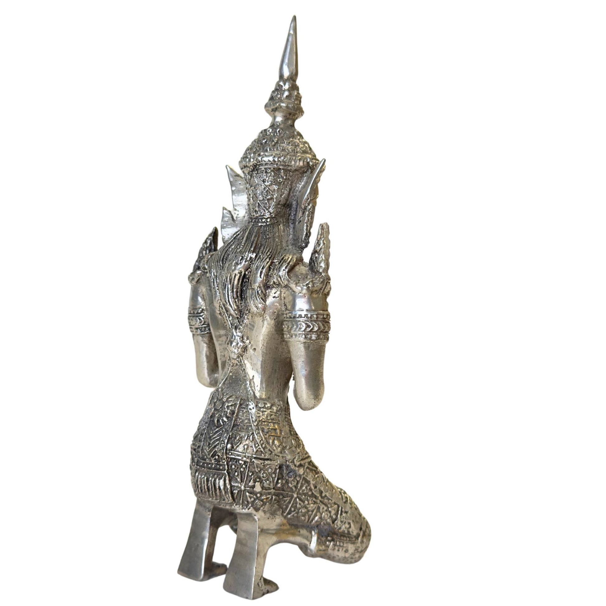 Rear view of a silver-plated Thai angel with a detailed robe.