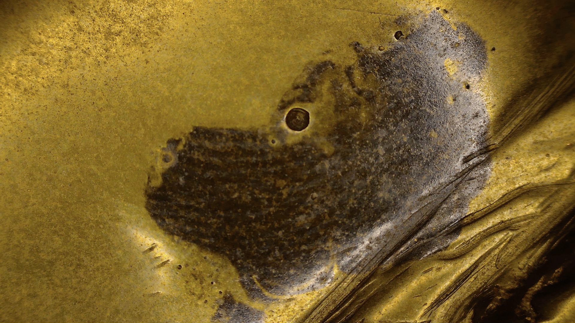 Microscoopdetail van het bruine patinavlak op antieke Tibetaanse bronzen Boeddha