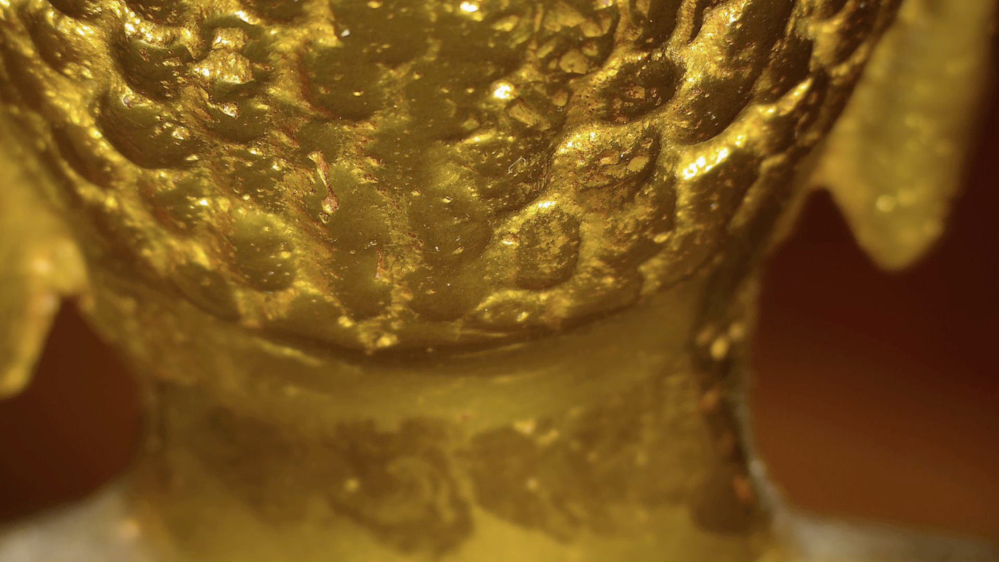 Microscoopdetail van oude vergulding en gelaagde patina op antieke Tibetaanse Boeddha