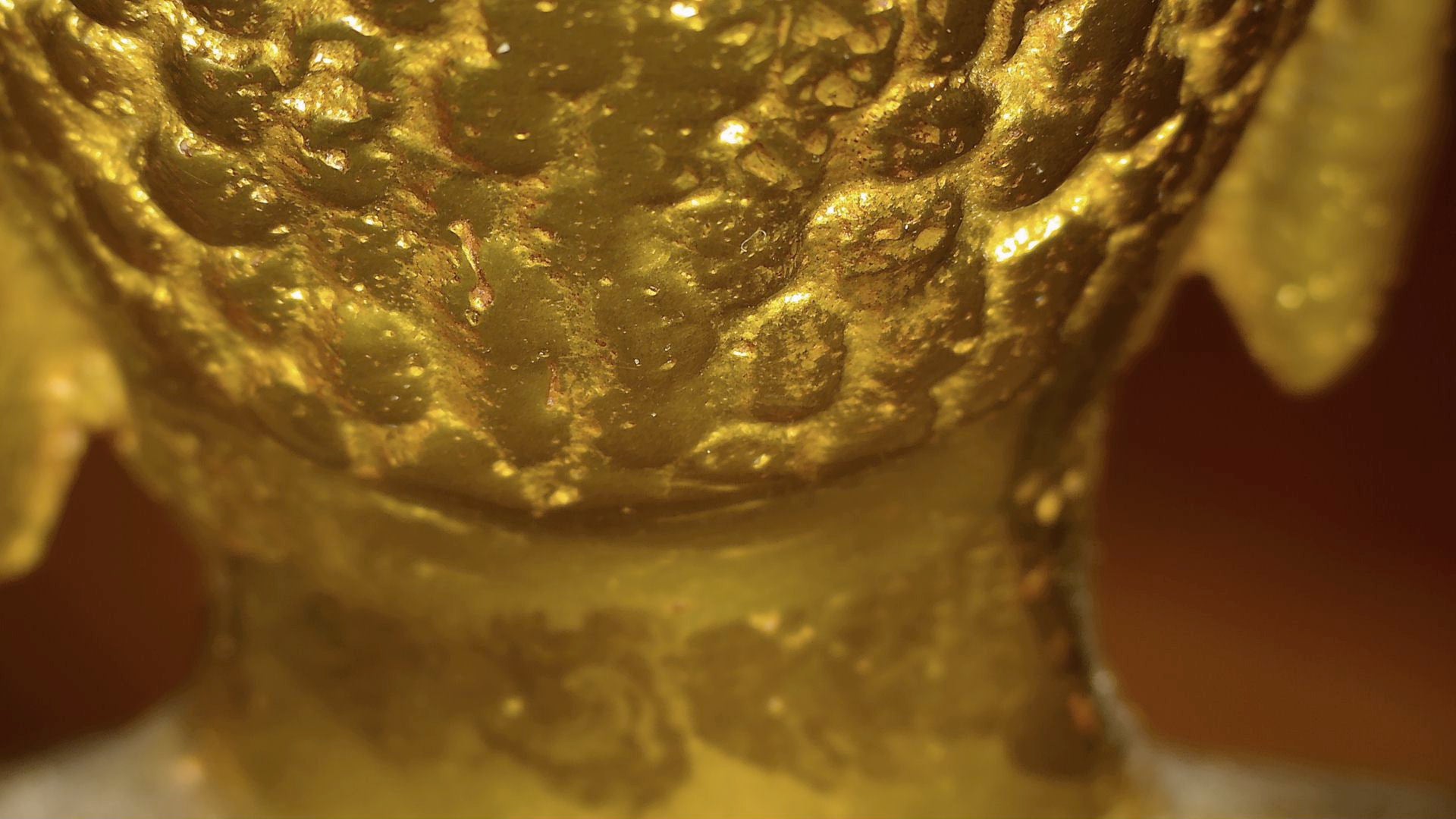 Microscoopdetail van oude vergulding en gelaagde patina op antieke Tibetaanse Boeddha