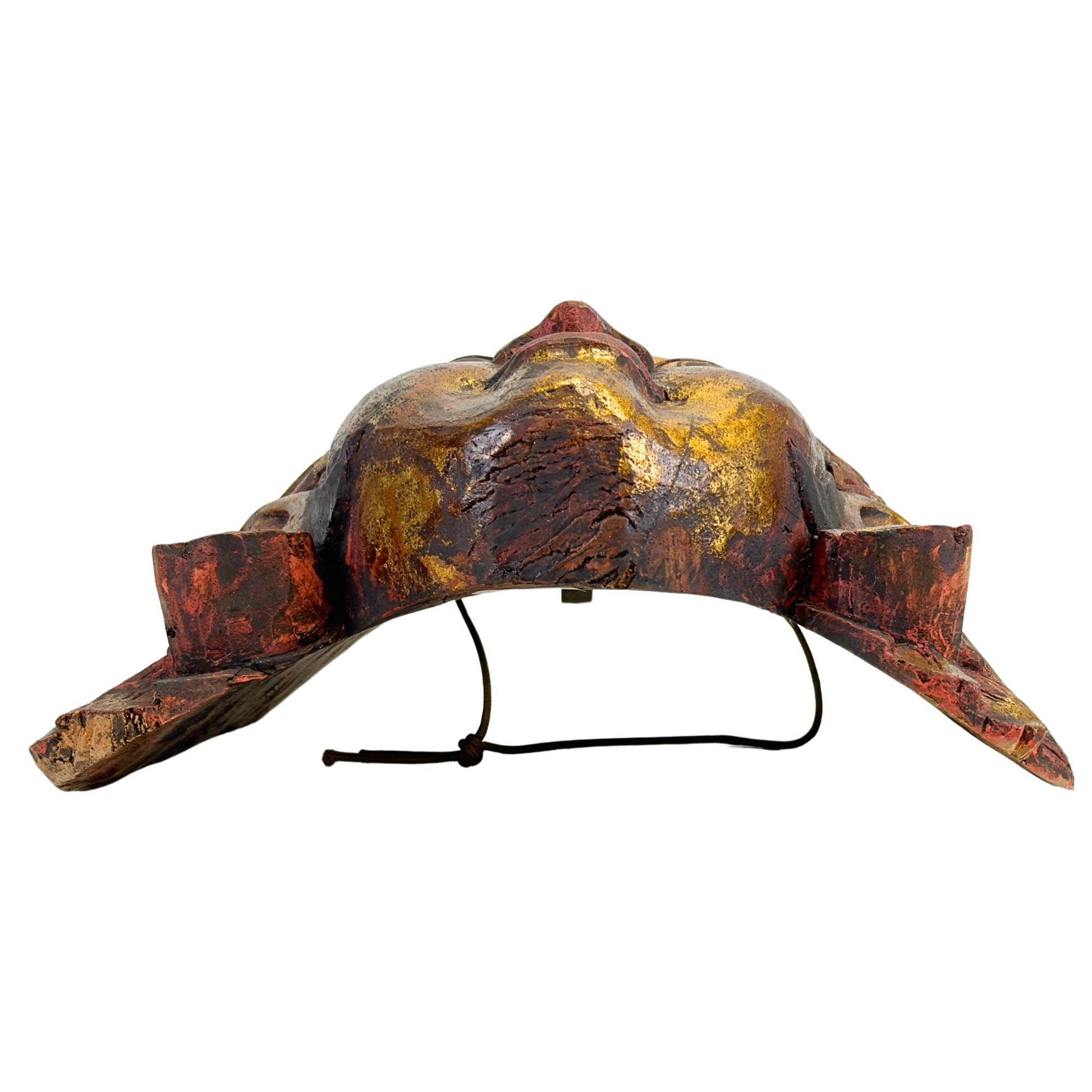 Bottom view of the Balinese Topeng mask, focusing on the functional, horizontal viewing slits under the eyelids and the ergonomic indentation for the dancer.