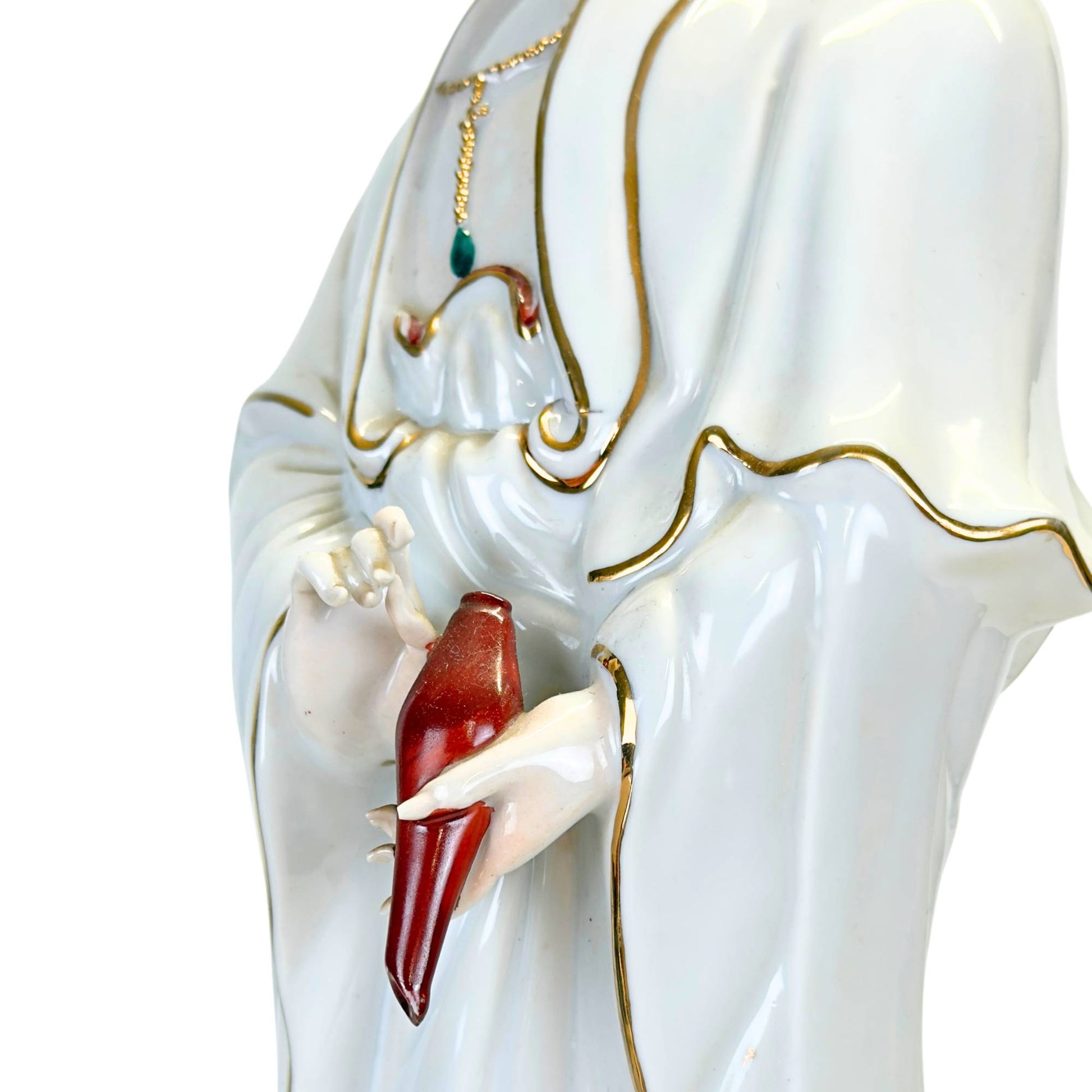 Detail of the gilded accents on a traditional Chinese porcelain figurine.