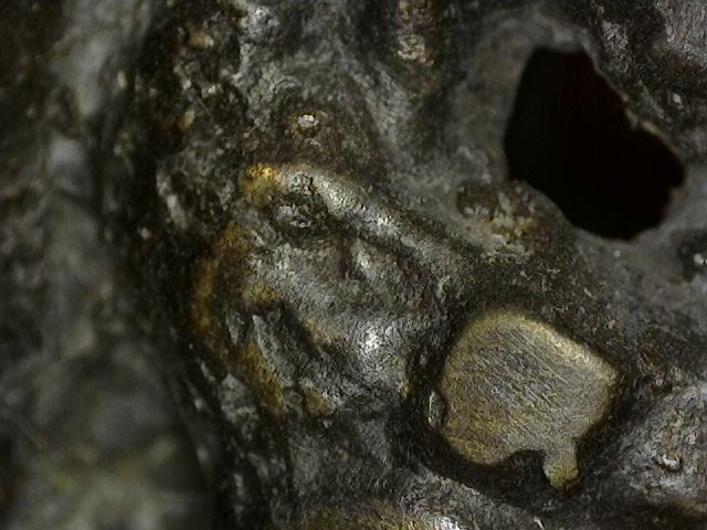 Microscopic detail of rounded wear of fire gilding on a historic Vishnu bust