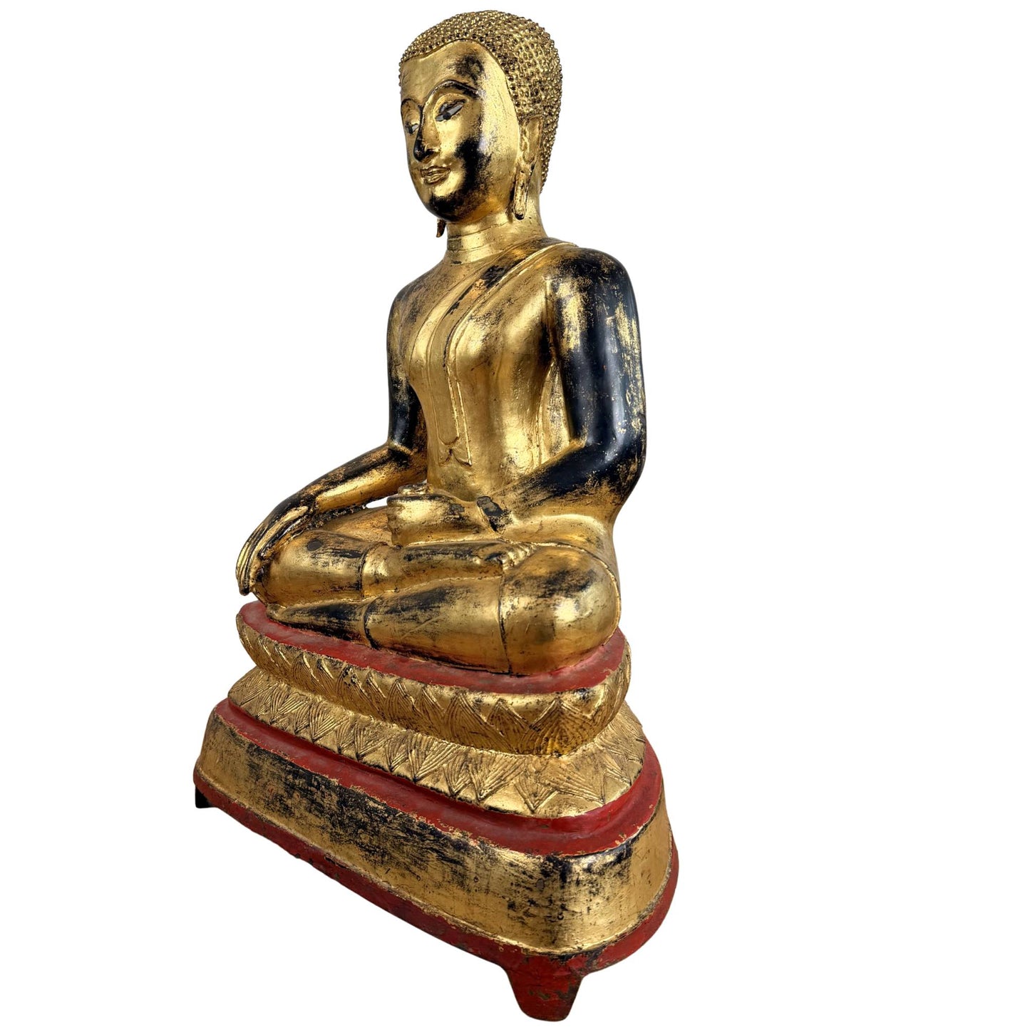 Fire-gilded bronze Buddha as a temple statue with natural wear, red accents, and a classic seated posture.
