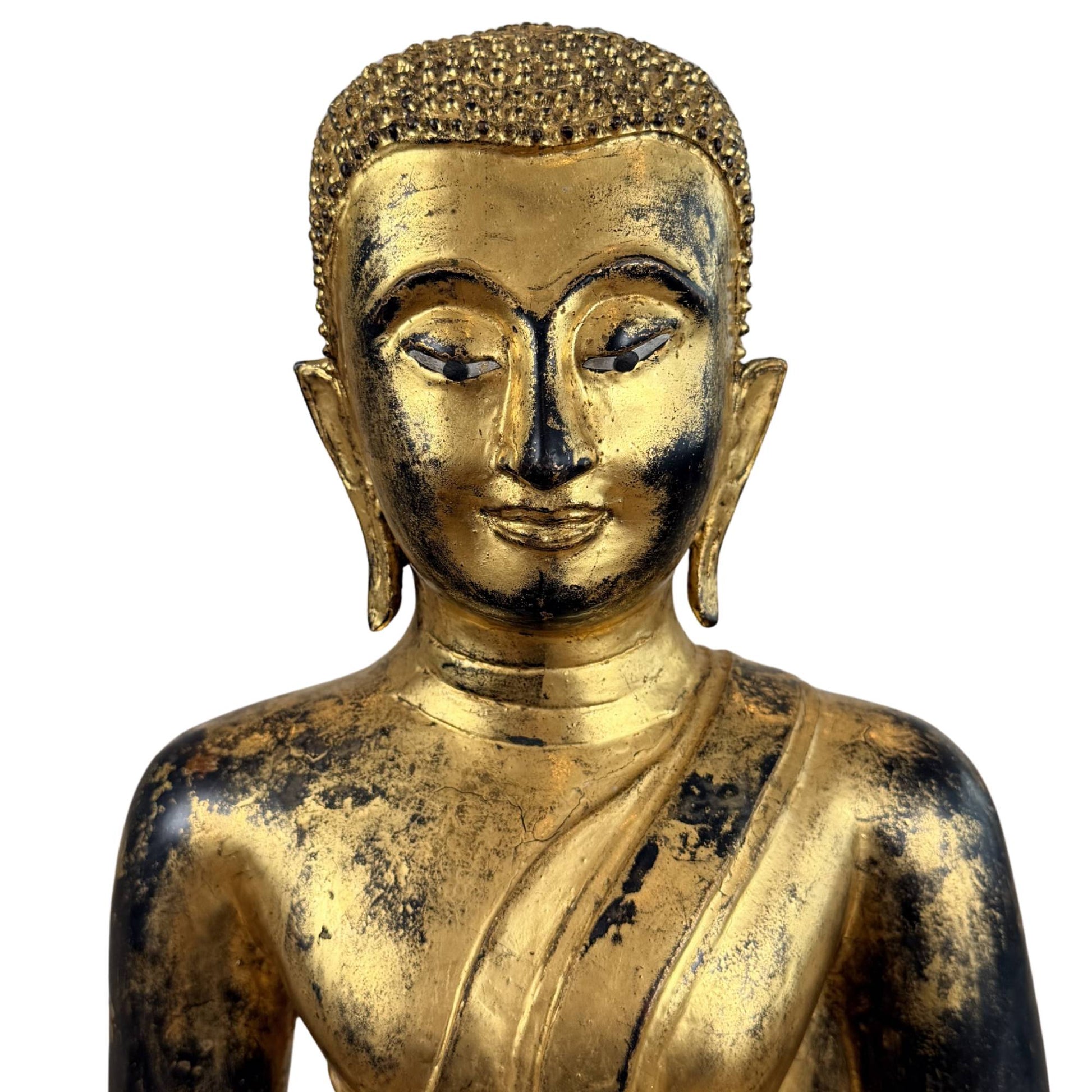 Fire-gilded bronze Buddha with red accents, inlaid eyes, and decorative lotus base