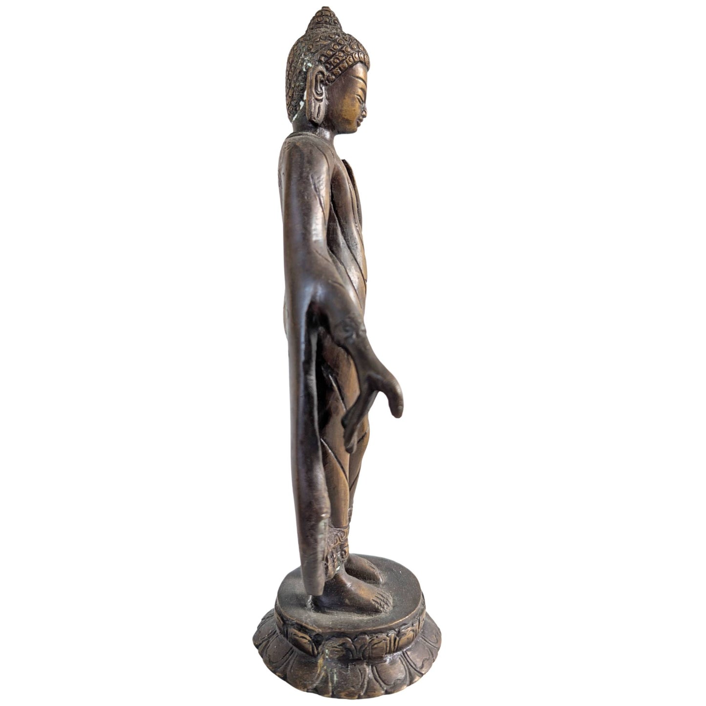 Side view of the standing Buddha figure with flowing robes in bronze.
