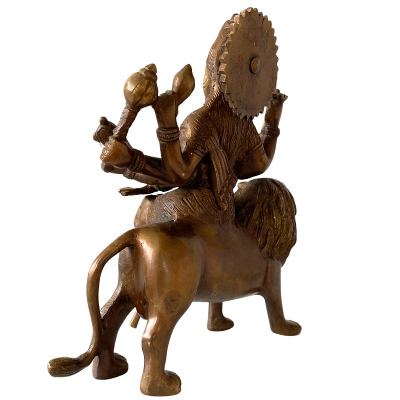 Side view of bronze Durga on a lion – ancient Hindu statue