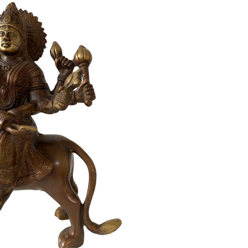 Side view of bronze Durga on a lion – ancient Hindu statue