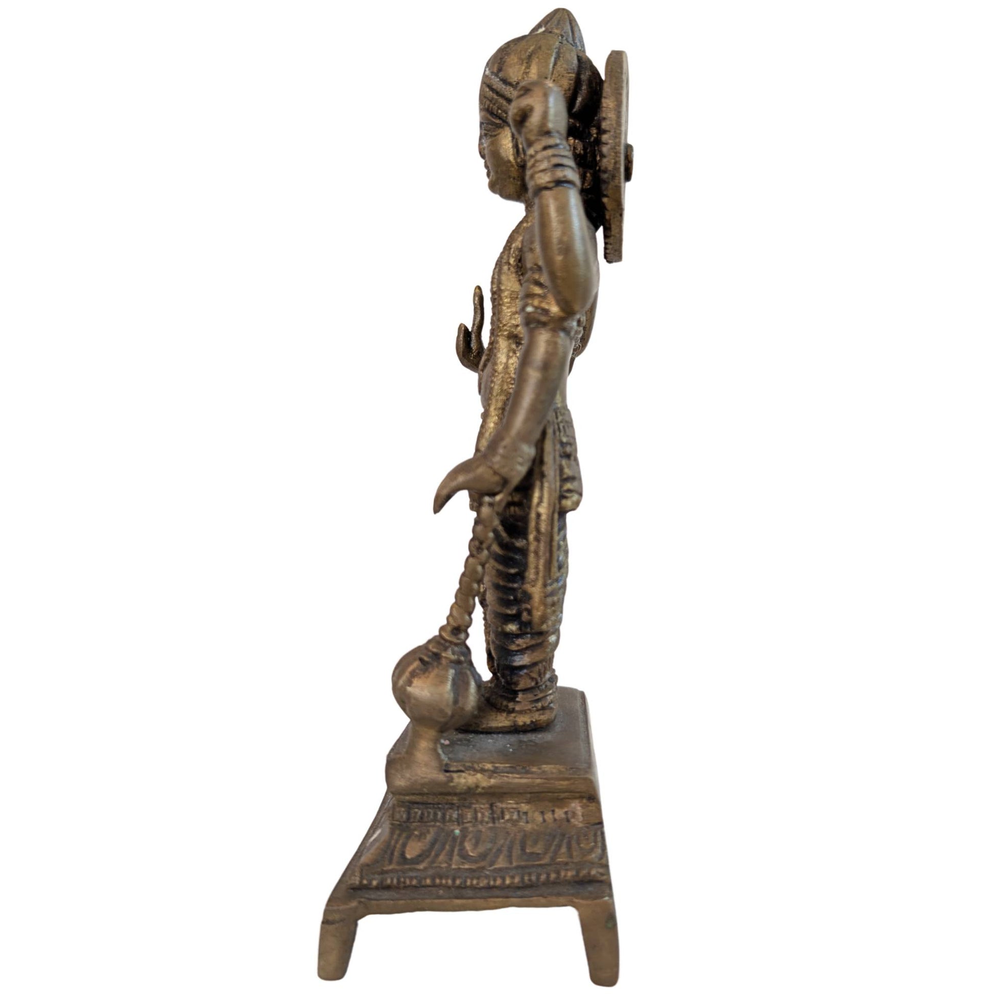 Left side profile of an antique bronze Vishnu statue focusing on the Shanka shell